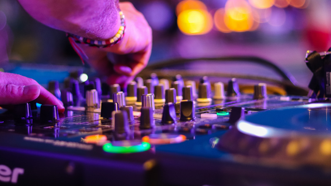 DJ turns knobs on a mixer