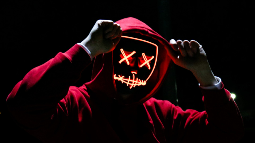 man with red hoody and light up mask